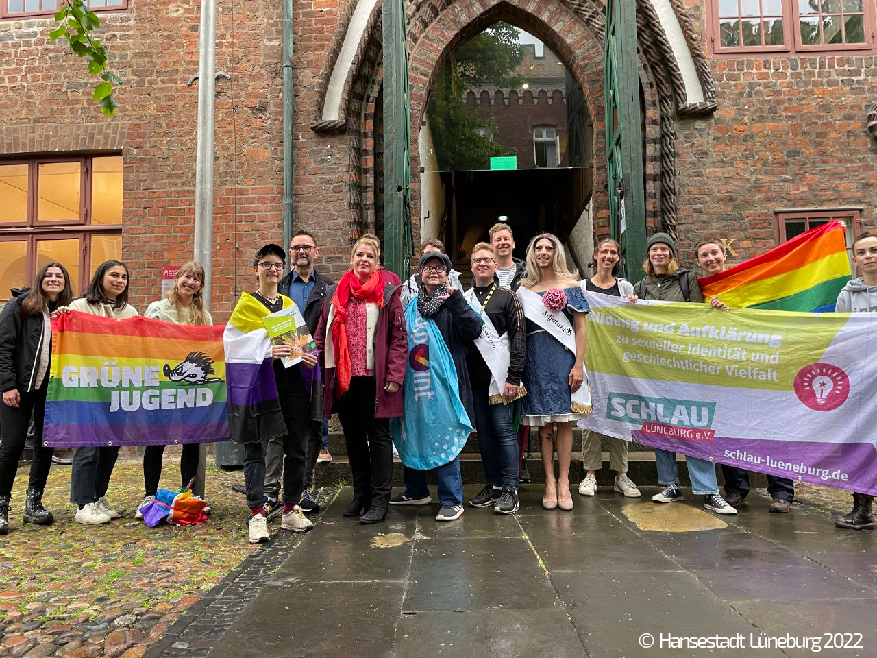 Die Oberbürgermeister der Stadt Lüneburg Claudia Kalisch steht mit verschiedenen Verterter:innen von LSBTI/queeren Organisationen vor dem Eingang des Lüneburger Rathauses